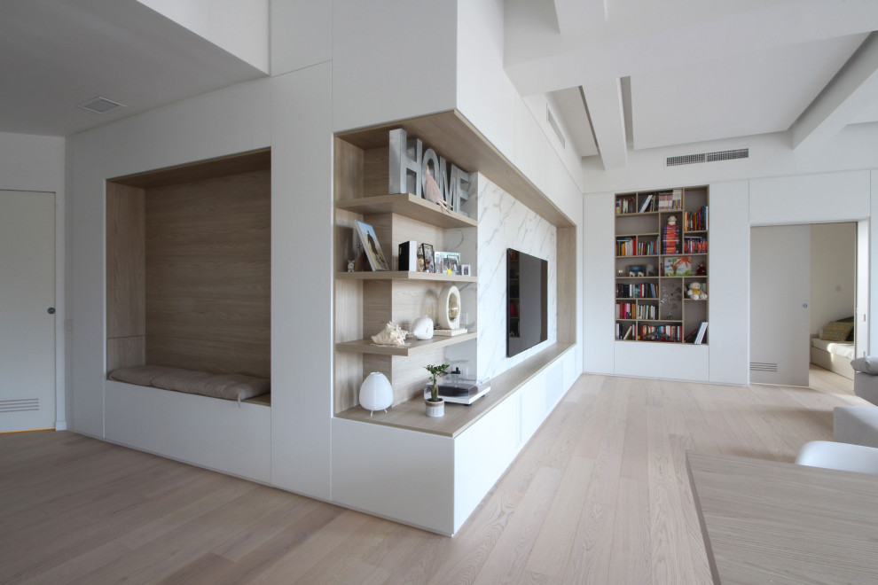 Bild på ett stort minimalistiskt allrum på loftet, med ett bibliotek, vita väggar, mellanmörkt trägolv, en inbyggd mediavägg och brunt golv
