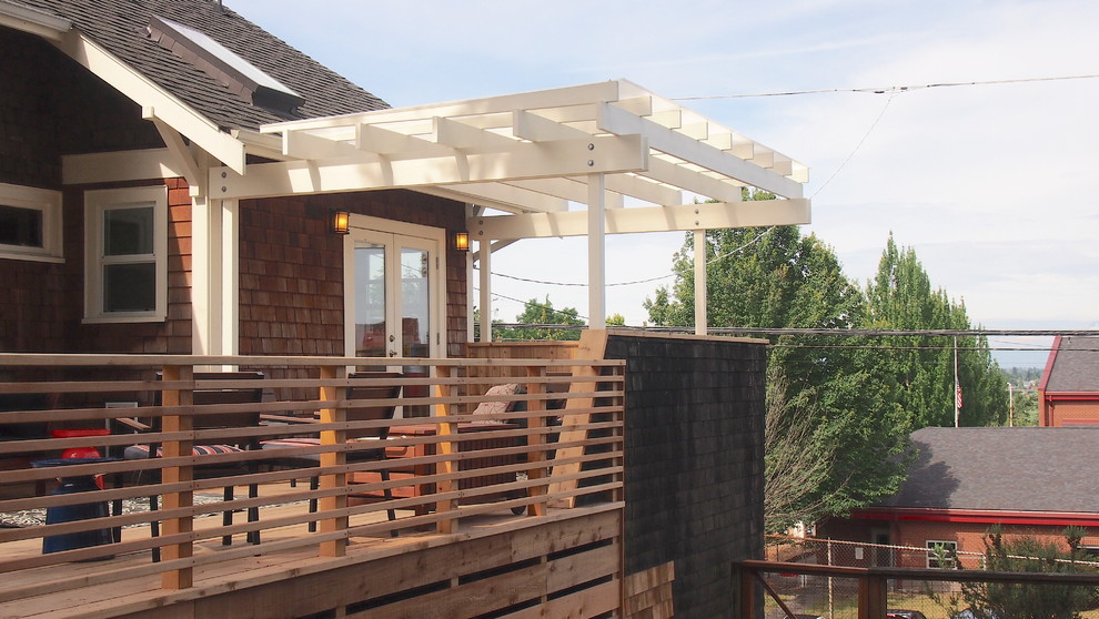 Example of a mid-sized arts and crafts backyard deck design in Seattle with a pergola