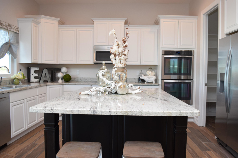 Example of a mid-sized transitional u-shaped porcelain tile open concept kitchen design in Phoenix with a double-bowl sink, raised-panel cabinets, white cabinets, granite countertops, gray backsplash, stone slab backsplash, stainless steel appliances and an island