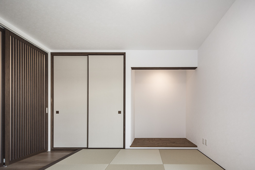 Modern guest bedroom in Osaka with white walls, tatami floors and no fireplace.