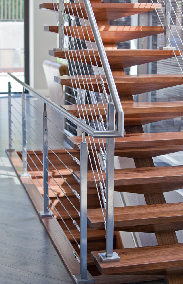 This is an example of a large contemporary wood floating staircase in Vancouver with open risers.