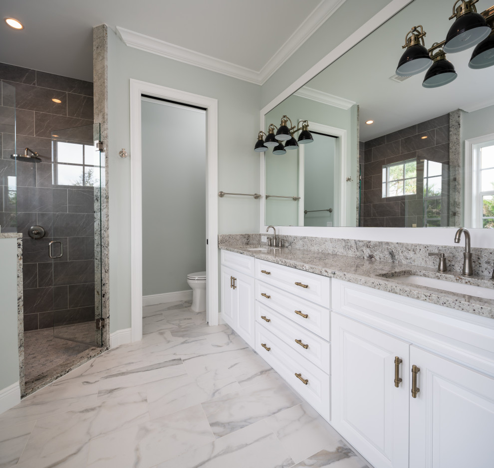 Inspiration for a mid-sized transitional 3/4 bathroom in Other with raised-panel cabinets, white cabinets, a two-piece toilet, green walls, ceramic floors, an undermount sink, marble benchtops, multi-coloured floor, a hinged shower door and multi-coloured benchtops.