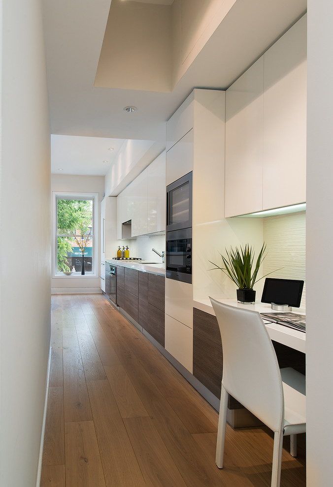 Design ideas for a small contemporary single-wall open plan kitchen in DC Metro with flat-panel cabinets, white cabinets, medium hardwood floors, no island, an undermount sink, quartz benchtops, white splashback, glass tile splashback and stainless steel appliances.