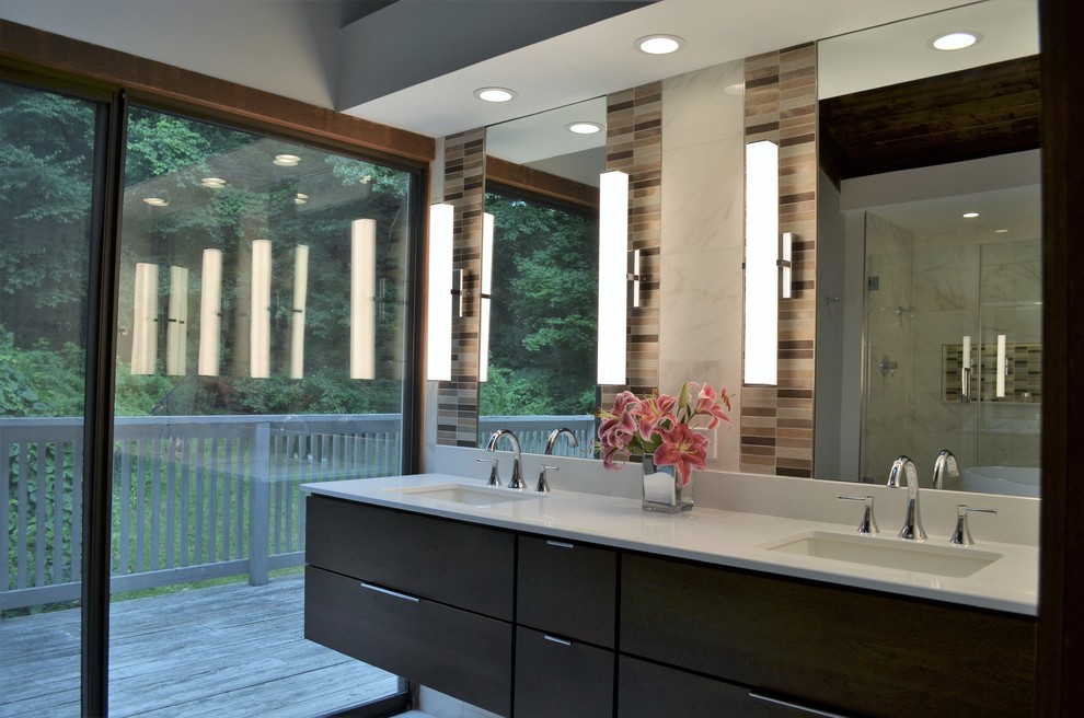 Inspiration for a mid-sized modern master bathroom in Bridgeport with flat-panel cabinets, brown cabinets, a freestanding tub, an alcove shower, a one-piece toilet, white tile, porcelain tile, grey walls, porcelain floors, an undermount sink, engineered quartz benchtops, white floor, a hinged shower door and white benchtops.