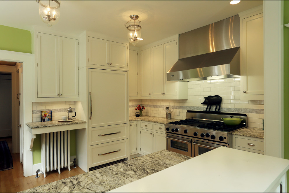 Design ideas for a mid-sized traditional u-shaped eat-in kitchen in Portland with white cabinets, granite benchtops, white splashback, subway tile splashback, stainless steel appliances, light hardwood floors, a peninsula, a farmhouse sink and shaker cabinets.