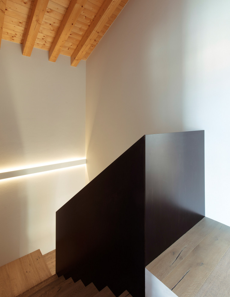 Mid-sized contemporary wood u-shaped staircase in Venice with wood risers and metal railing.