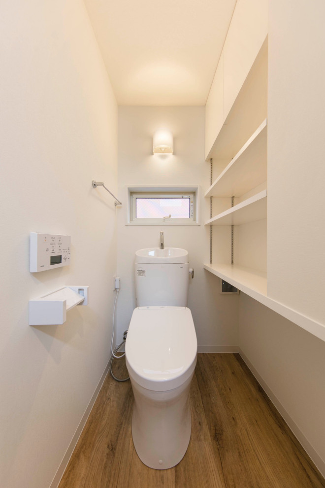 Mid-sized scandinavian powder room in Tokyo with beaded inset cabinets, white cabinets, a one-piece toilet, multi-coloured tile, mosaic tile, purple walls, light hardwood floors, an undermount sink, solid surface benchtops, beige floor, white benchtops, a built-in vanity, wallpaper and brick walls.
