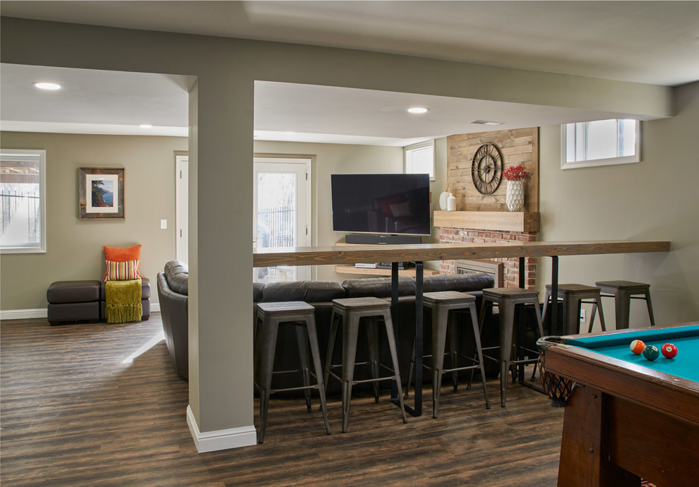 Inspiration for a large rustic walk-out vinyl floor and brown floor basement remodel in St Louis with gray walls, a standard fireplace and a brick fireplace