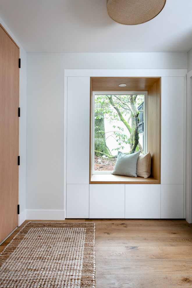 Bild på en mellanstor minimalistisk foajé, med grå väggar, mellanmörkt trägolv, en enkeldörr, ljus trädörr och brunt golv