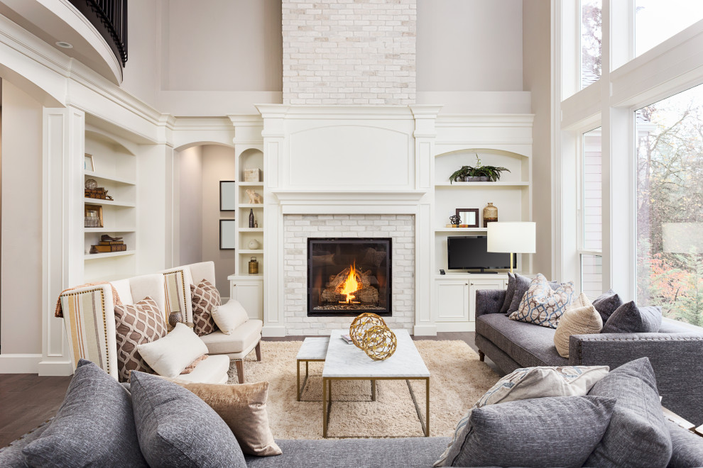 This is an example of an expansive classic open plan living room in San Francisco with white walls, medium hardwood flooring, a standard fireplace, a brick fireplace surround and brown floors.