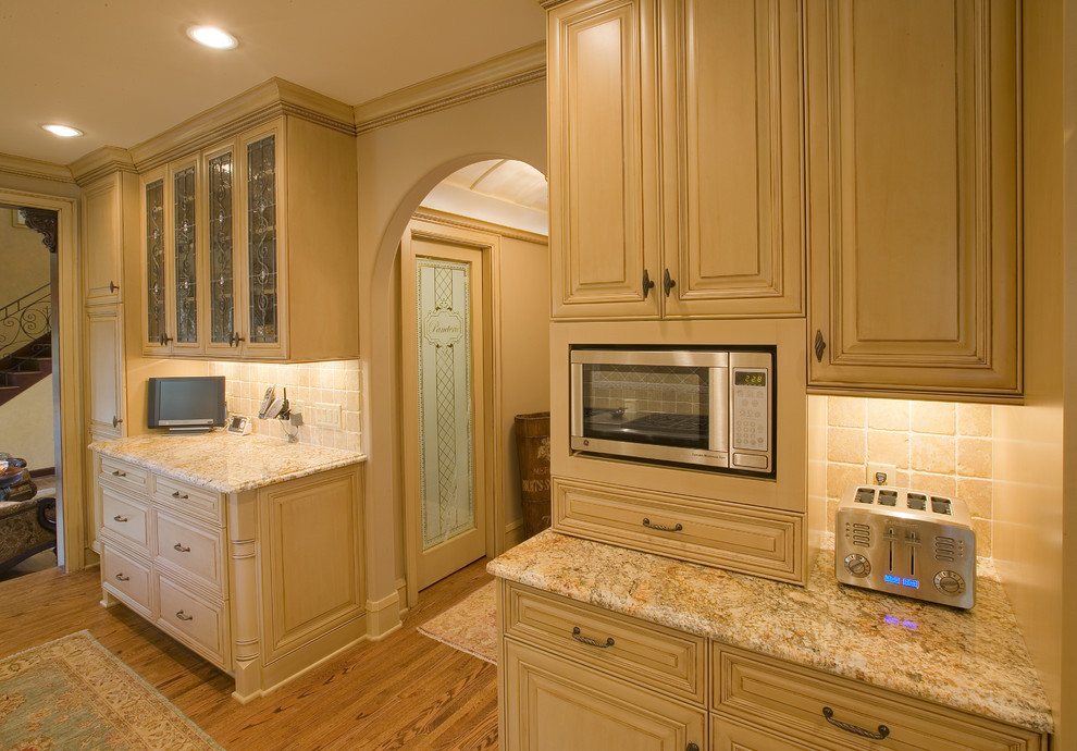 This is an example of a mid-sized traditional galley separate kitchen in Minneapolis with granite benchtops, stainless steel appliances, no island, an undermount sink, raised-panel cabinets and medium hardwood floors.