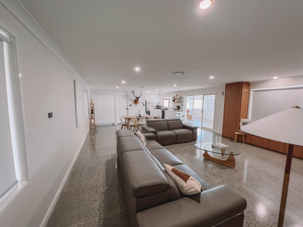 Foto di un soggiorno scandinavo di medie dimensioni e aperto con pareti bianche, pavimento in cemento, TV autoportante, pavimento grigio, soffitto in legno e pareti in legno