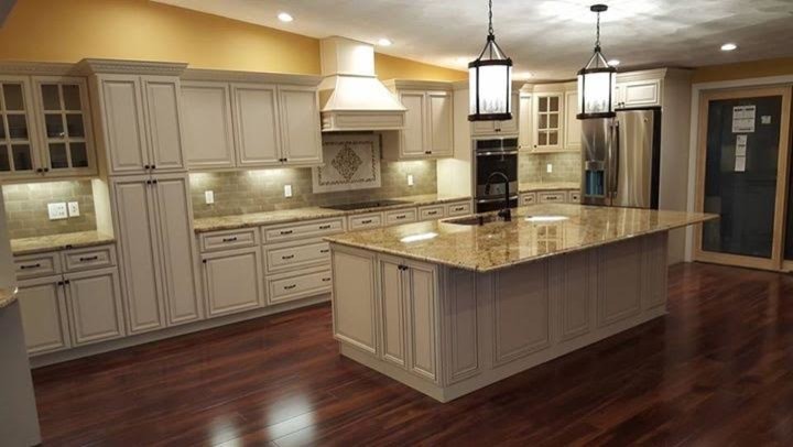 Example of a large transitional l-shaped dark wood floor kitchen design in Boston with an undermount sink, raised-panel cabinets, granite countertops, gray backsplash, stone tile backsplash and an island