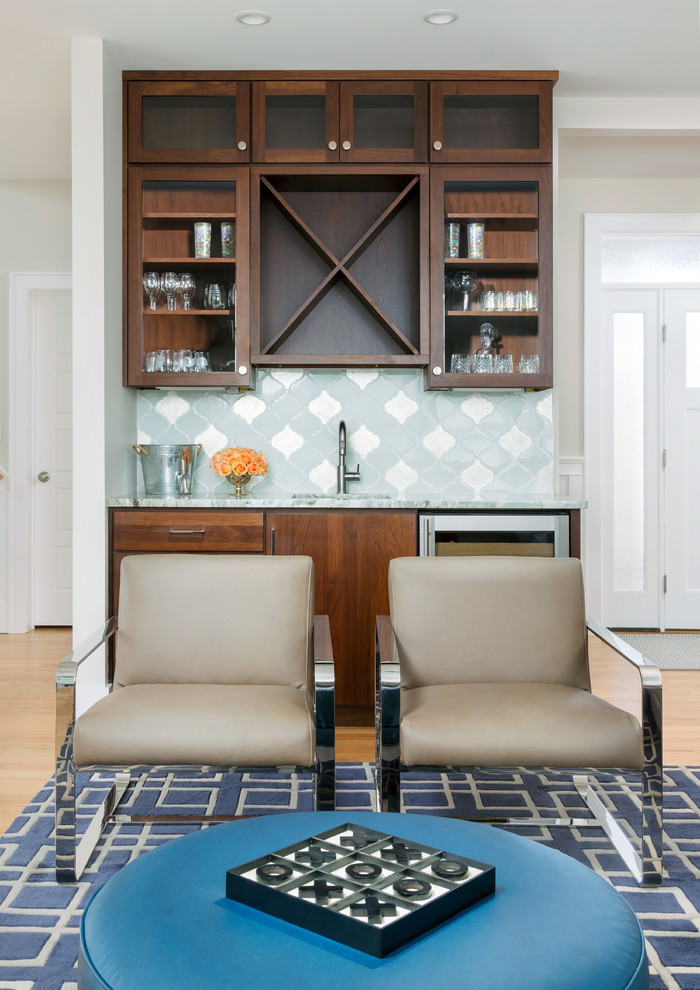 This is an example of a beach style home bar in Baltimore with glass-front cabinets, dark wood cabinets, quartz benchtops, white splashback and ceramic splashback.