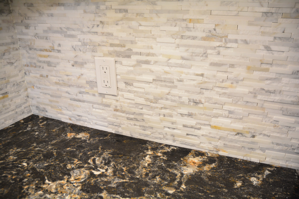 Small transitional l-shaped medium tone wood floor and brown floor eat-in kitchen photo with an undermount sink, raised-panel cabinets, green cabinets, quartz countertops, white backsplash, marble backsplash, black appliances, an island and multicolored countertops
