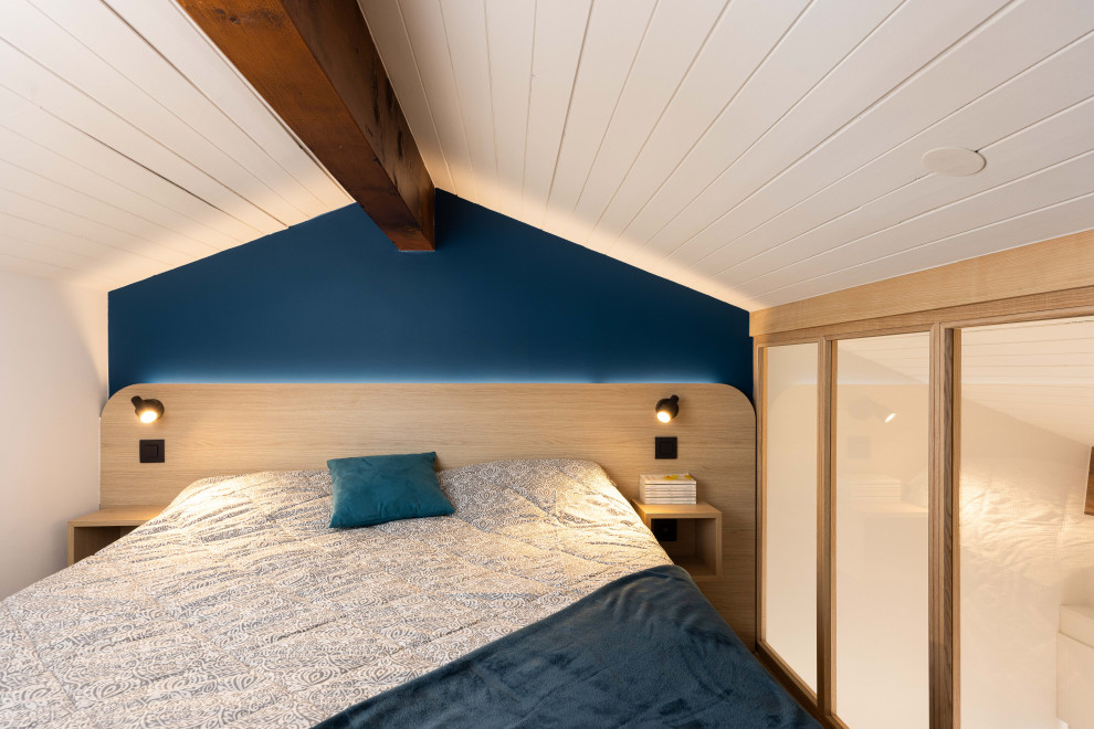Kleines Skandinavisches Schlafzimmer im Loft-Style mit blauer Wandfarbe, hellem Holzboden und Holzdielendecke in Sonstige