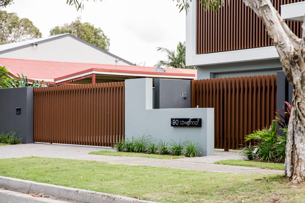 Inspiration for a mid-sized contemporary two-storey grey house exterior in Sunshine Coast with mixed siding, a flat roof and a metal roof.