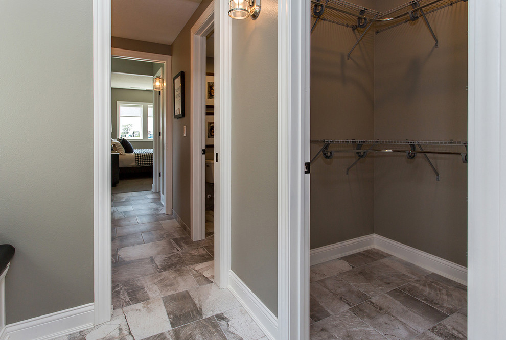This is an example of a small transitional gender-neutral walk-in wardrobe in Other with ceramic floors and brown floor.