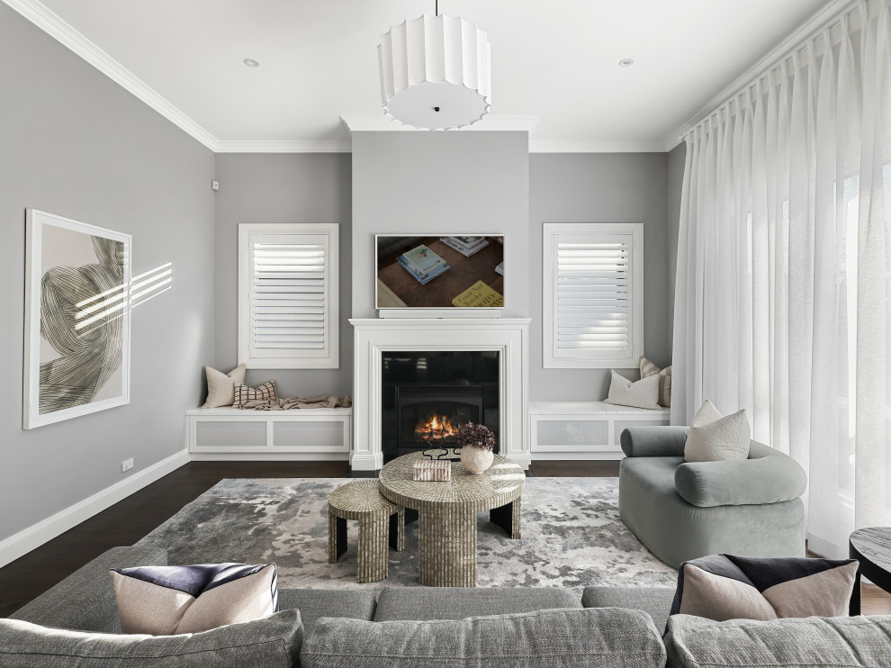 Design ideas for a medium sized contemporary open plan living room in Sydney with grey walls, dark hardwood flooring, a standard fireplace, a wooden fireplace surround, a wall mounted tv and brown floors.