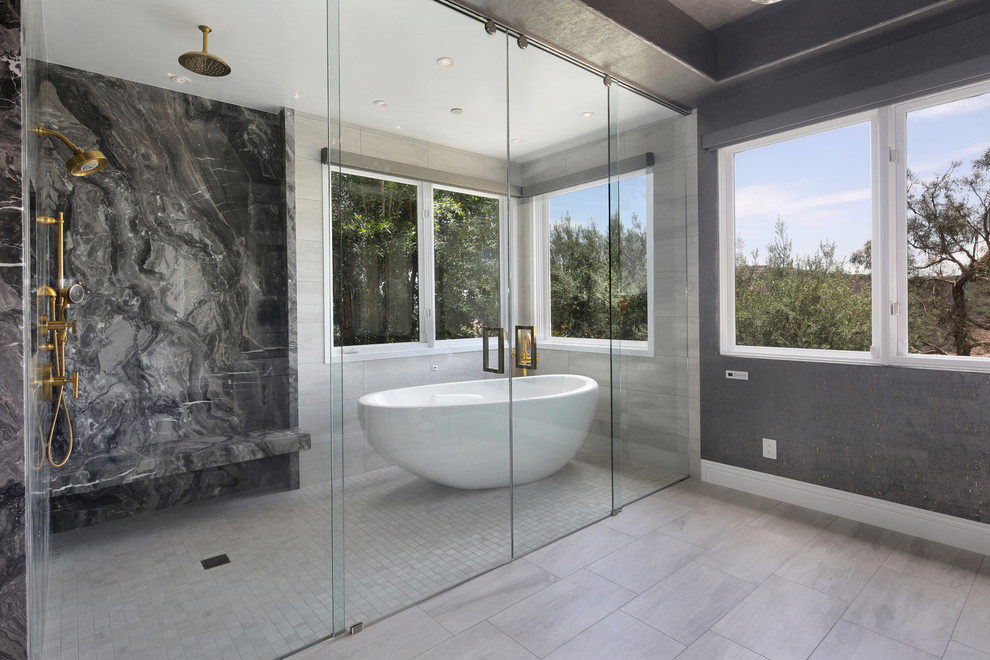 This is an example of a mid-sized contemporary master wet room bathroom in Orange County with shaker cabinets, white cabinets, a freestanding tub, black and white tile, marble, grey walls, light hardwood floors, engineered quartz benchtops, grey floor, a sliding shower screen and grey benchtops.