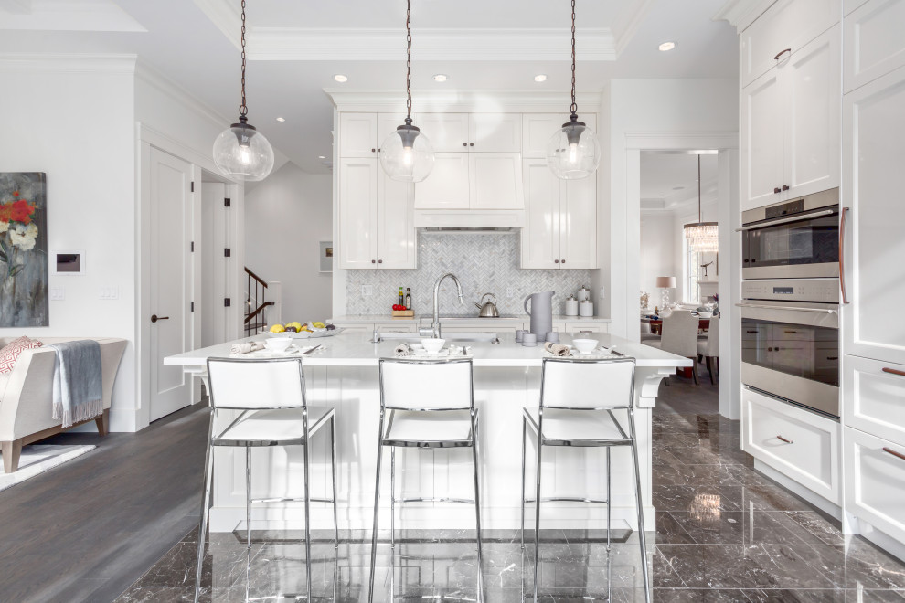 Transitional black floor open concept kitchen photo in Vancouver with shaker cabinets, white cabinets, multicolored backsplash, stainless steel appliances, an island and white countertops