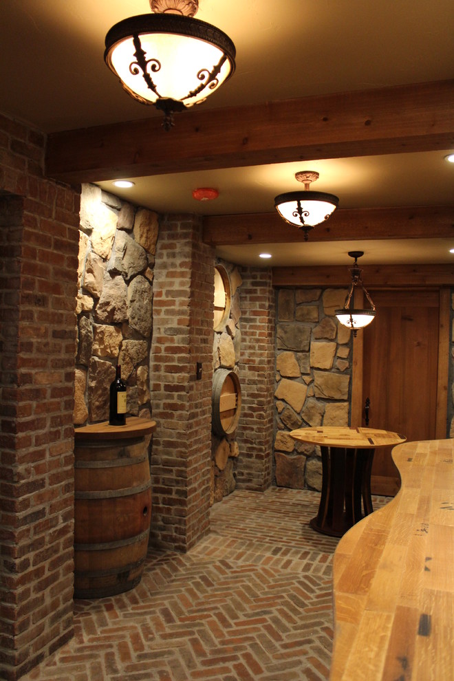Wine cellar - rustic brick floor wine cellar idea in Boston