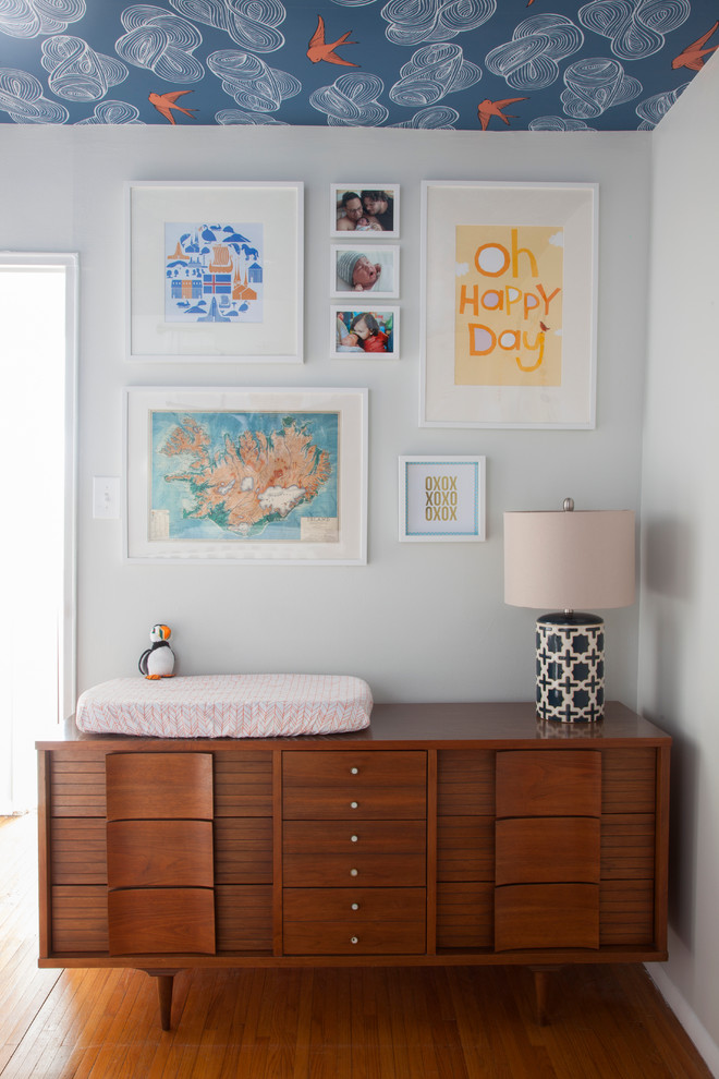 This is an example of a transitional gender-neutral nursery in Philadelphia with white walls and orange floor.