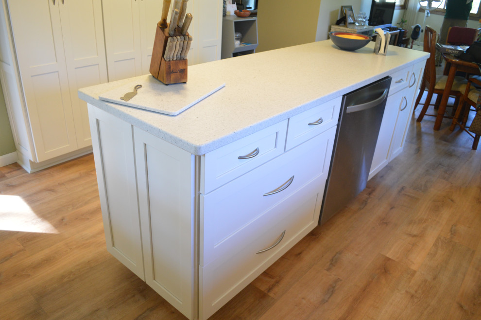 Inspiration for a small transitional single-wall vinyl floor eat-in kitchen remodel with an undermount sink, shaker cabinets, gray cabinets, solid surface countertops, stainless steel appliances, an island and white countertops