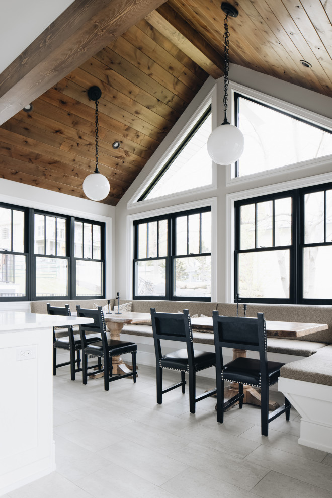 Esempio di una grande sala da pranzo aperta verso il soggiorno stile rurale con pareti bianche, pavimento in gres porcellanato, pavimento grigio e soffitto in legno