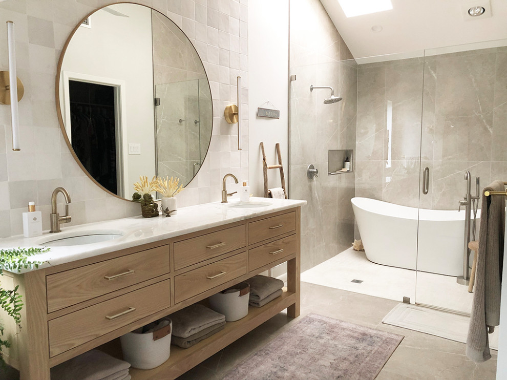 Inspiration for a modern master wet room bathroom in Dallas with flat-panel cabinets, light wood cabinets, a freestanding tub, white tile, ceramic tile, white walls, porcelain floors, an undermount sink, marble benchtops, beige floor, a hinged shower door, white benchtops, a double vanity, a freestanding vanity and vaulted.