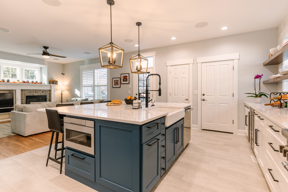 This is an example of a large country l-shaped open plan kitchen in Denver with a single-bowl sink, shaker cabinets, blue cabinets, quartz worktops, white splashback, ceramic splashback, stainless steel appliances, vinyl flooring, an island, beige floors and white worktops.