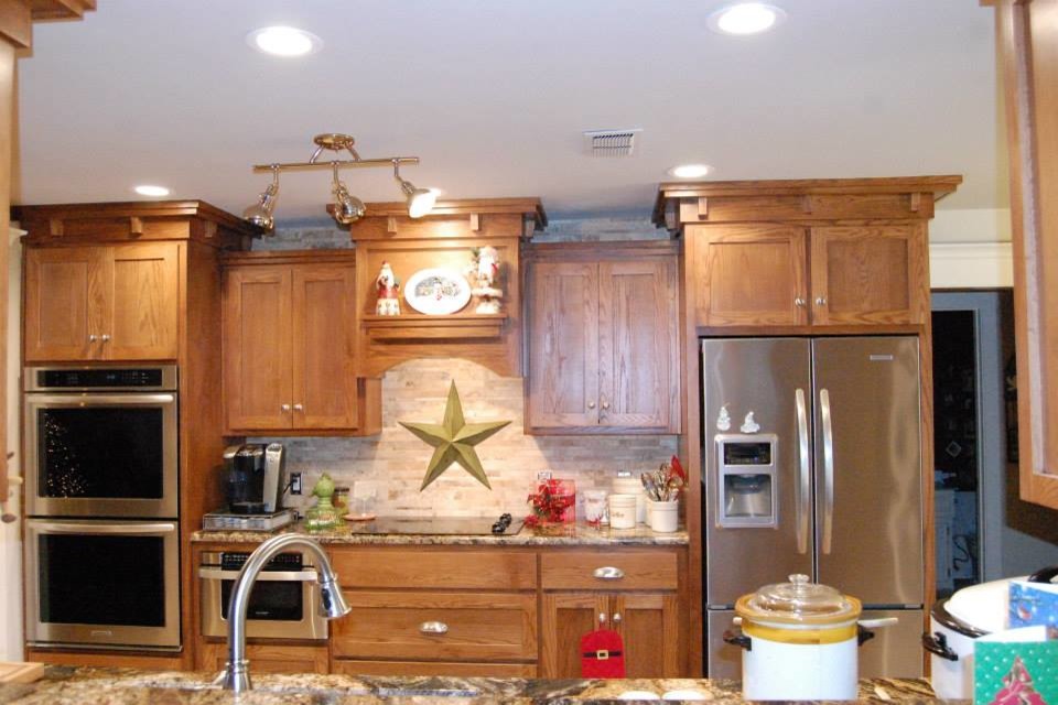 Photo of a mid-sized galley eat-in kitchen in Austin with a double-bowl sink, shaker cabinets, light wood cabinets, granite benchtops, beige splashback, stone tile splashback, stainless steel appliances, no island and travertine floors.
