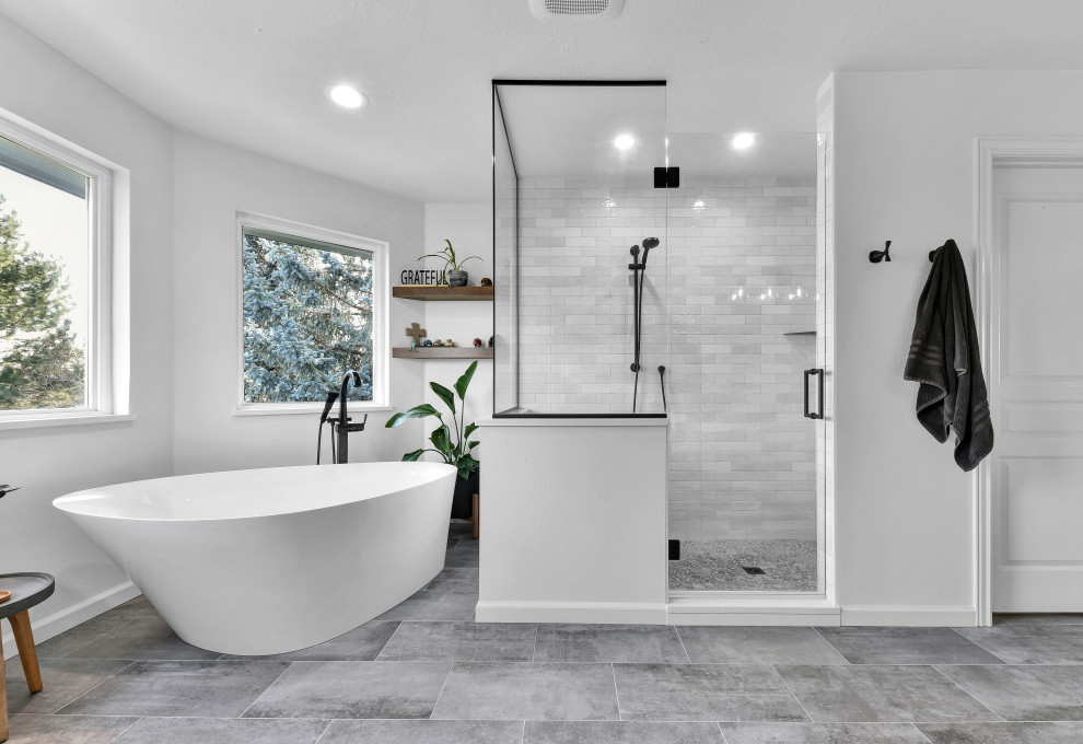 Inspiration for a large contemporary ensuite bathroom in Boise with shaker cabinets, white cabinets, a freestanding bath, a walk-in shower, white tiles, porcelain tiles, white walls, porcelain flooring, engineered stone worktops, grey floors, a hinged door, grey worktops, a shower bench, double sinks and a built in vanity unit.