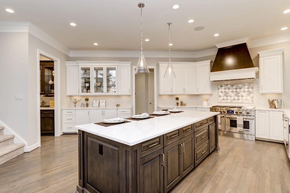 Inspiration for a large transitional u-shaped light wood floor and beige floor open concept kitchen remodel in DC Metro with an undermount sink, raised-panel cabinets, white cabinets, quartzite countertops, white backsplash, subway tile backsplash, stainless steel appliances and an island