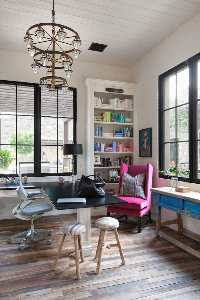 Inspiration for a mid-sized farmhouse built-in desk medium tone wood floor study room remodel in Phoenix with white walls and no fireplace