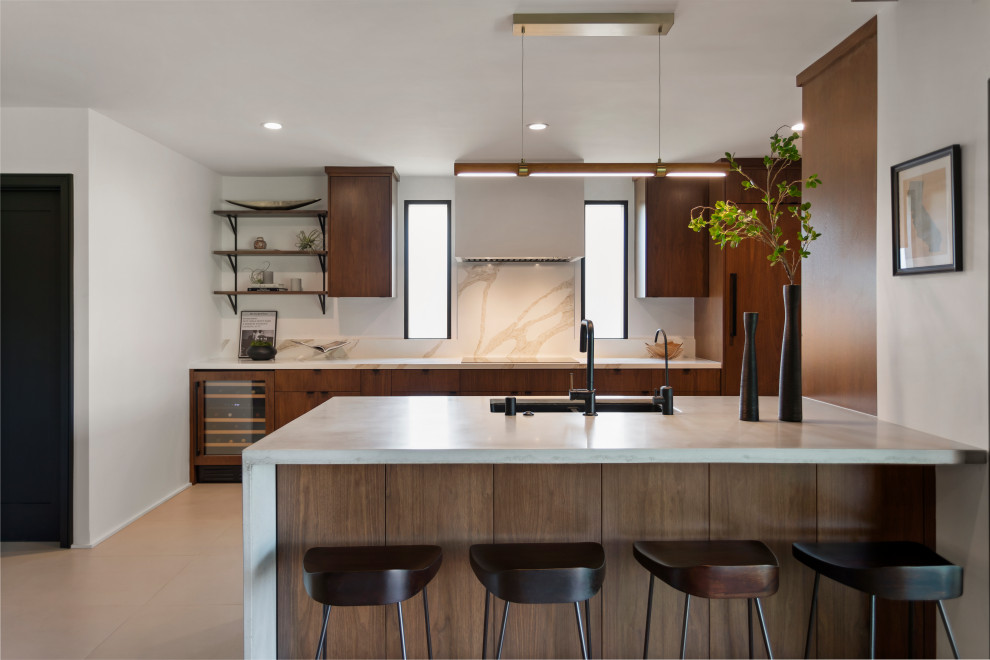 This is an example of a medium sized contemporary galley kitchen in Los Angeles with flat-panel cabinets, concrete worktops, engineered quartz splashback, integrated appliances, grey floors and grey worktops.
