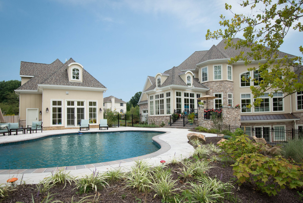 This is an example of a large traditional backyard custom-shaped lap pool in Wilmington with a pool house.