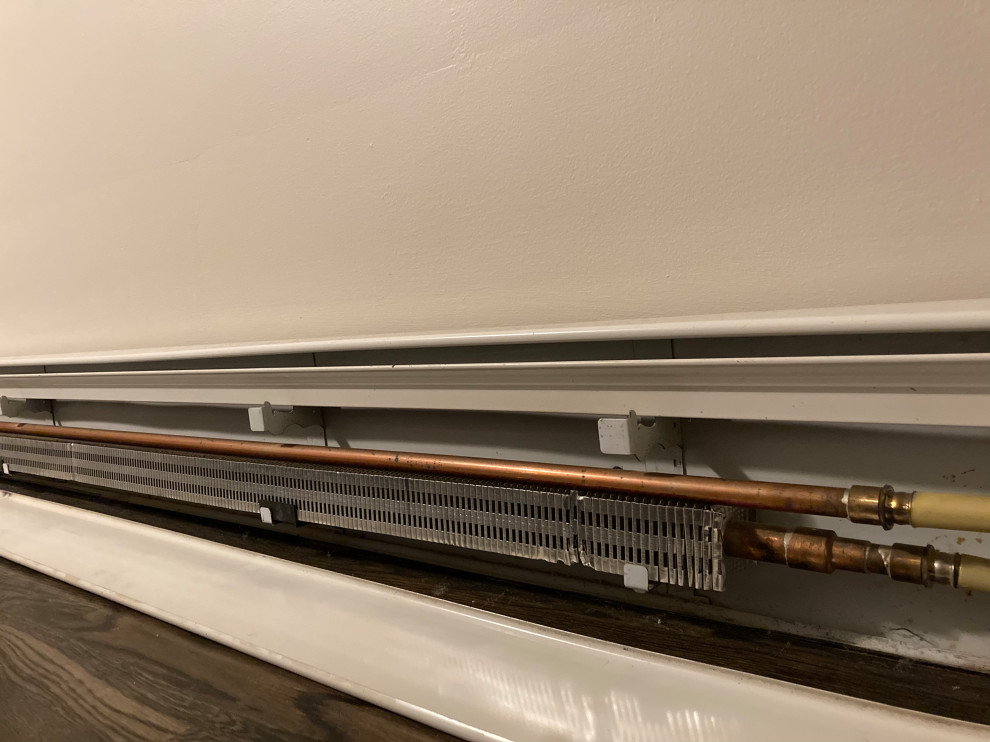 Baseboard heater return pipe on fins