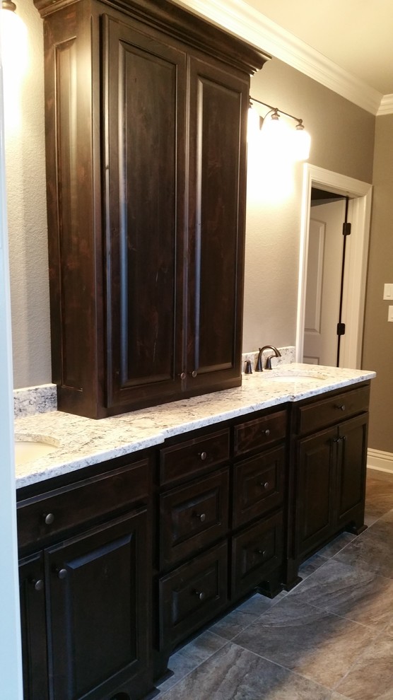 This is an example of a country bathroom in Little Rock with raised-panel cabinets, dark wood cabinets and granite benchtops.
