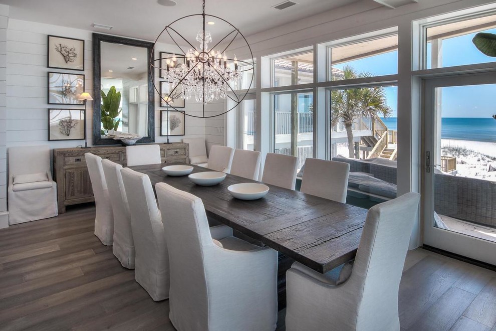 Inspiration for a mid-sized beach style dining room in Miami with white walls and dark hardwood floors.