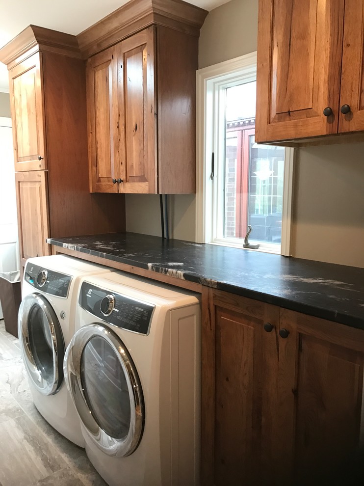 Inspiration for a mid-sized rustic galley dedicated laundry room remodel with raised-panel cabinets, granite countertops, a side-by-side washer/dryer and medium tone wood cabinets