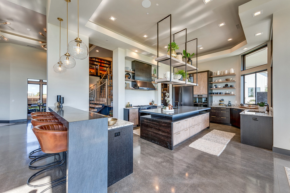 Large contemporary u-shaped open plan kitchen in Portland with with island, an undermount sink, flat-panel cabinets, light wood cabinets, granite benchtops, stainless steel appliances, concrete floors, grey floor and grey benchtop.