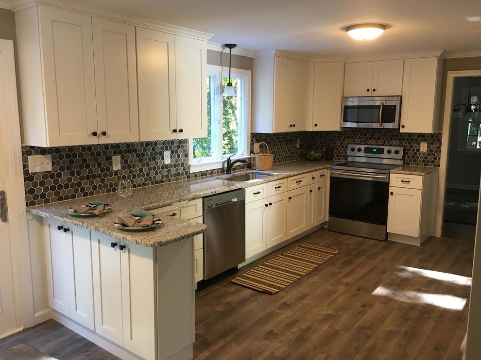 Photo of a mid-sized traditional galley eat-in kitchen in Bridgeport with an undermount sink, shaker cabinets, white cabinets, granite benchtops, multi-coloured splashback, mosaic tile splashback, stainless steel appliances, medium hardwood floors and a peninsula.