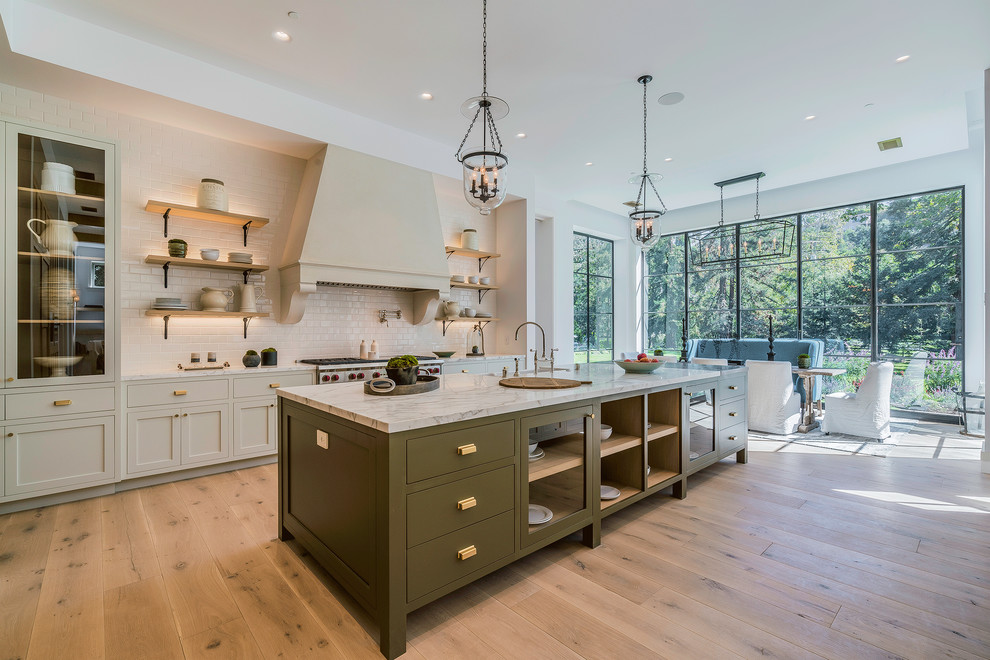 Design ideas for a large country galley eat-in kitchen in Los Angeles with a farmhouse sink, recessed-panel cabinets, marble benchtops, white splashback, subway tile splashback, stainless steel appliances, light hardwood floors, beige floor, light wood cabinets and with island.