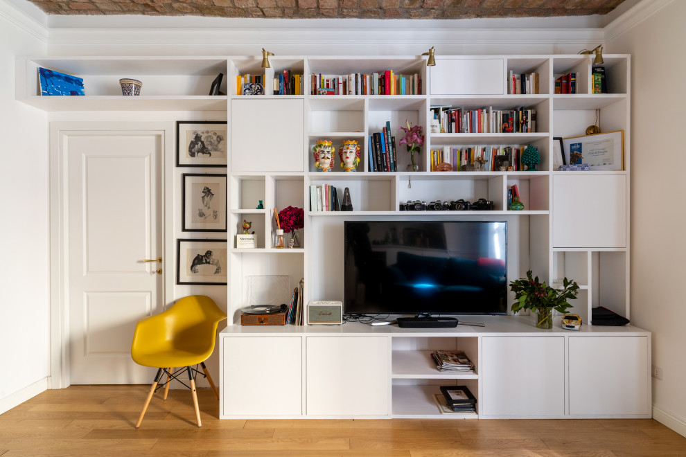 Immagine di un grande soggiorno moderno aperto con libreria, pareti bianche, parquet chiaro, nessun camino, parete attrezzata e pavimento beige