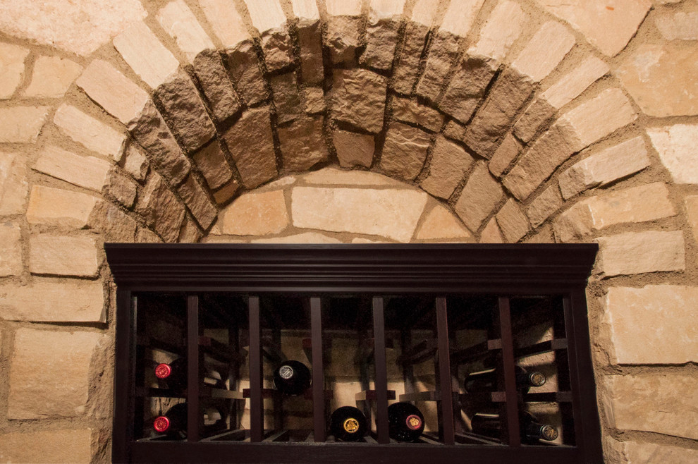 Mid-sized mediterranean wine cellar in San Diego with storage racks.