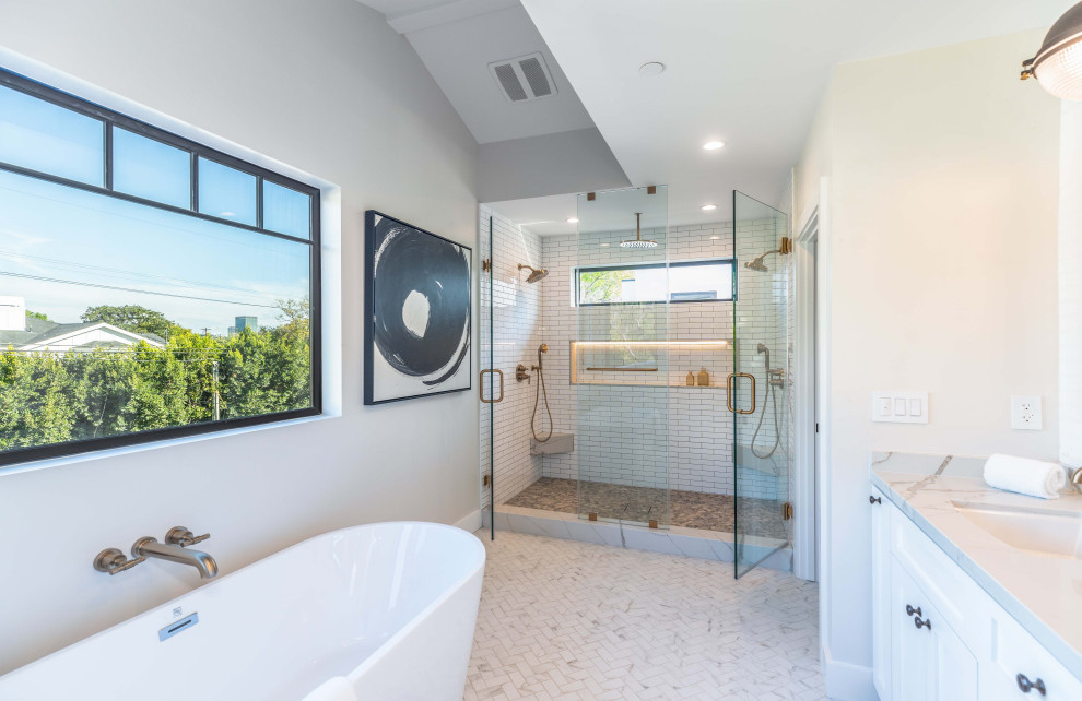 Photo of a country master bathroom in Los Angeles with shaker cabinets, white cabinets, a freestanding tub, a double shower, a one-piece toilet, white walls, mosaic tile floors, an undermount sink, marble benchtops, a hinged shower door, a double vanity and a built-in vanity.