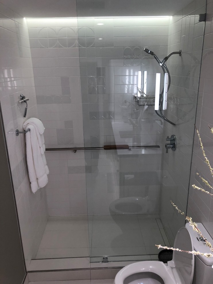 Photo of a small modern master bathroom in Dallas with glass-front cabinets, grey cabinets, an open shower, a one-piece toilet, white tile, ceramic tile, grey walls, porcelain floors, an undermount sink, engineered quartz benchtops, white floor, an open shower and white benchtops.