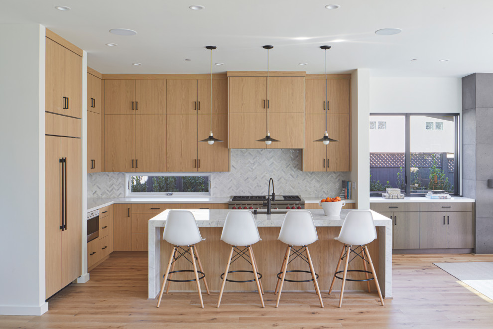 Inspiration for a contemporary l-shaped kitchen in San Francisco with an undermount sink, flat-panel cabinets, light wood cabinets, white splashback, stainless steel appliances, medium hardwood floors, with island, brown floor and white benchtop.