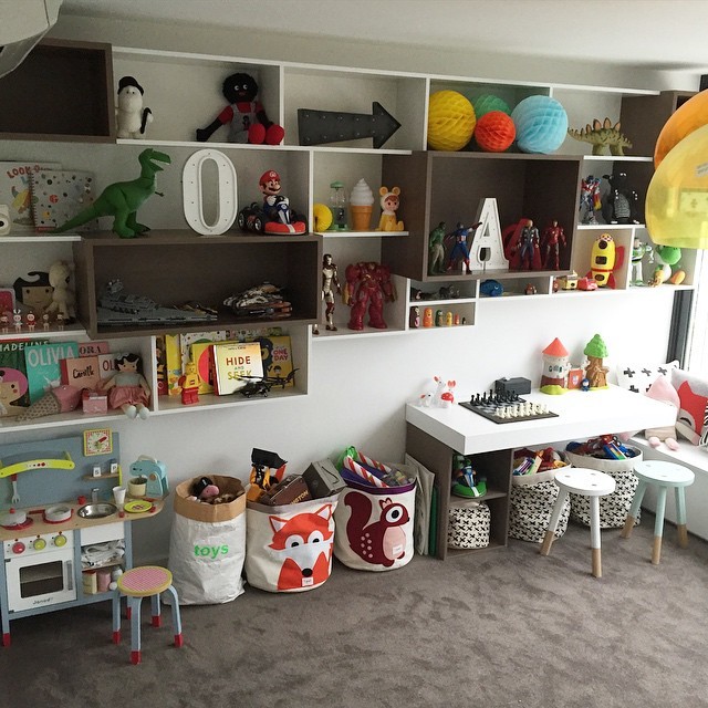 This is an example of a mid-sized contemporary gender-neutral kids' playroom for kids 4-10 years old in Sydney with white walls and carpet.